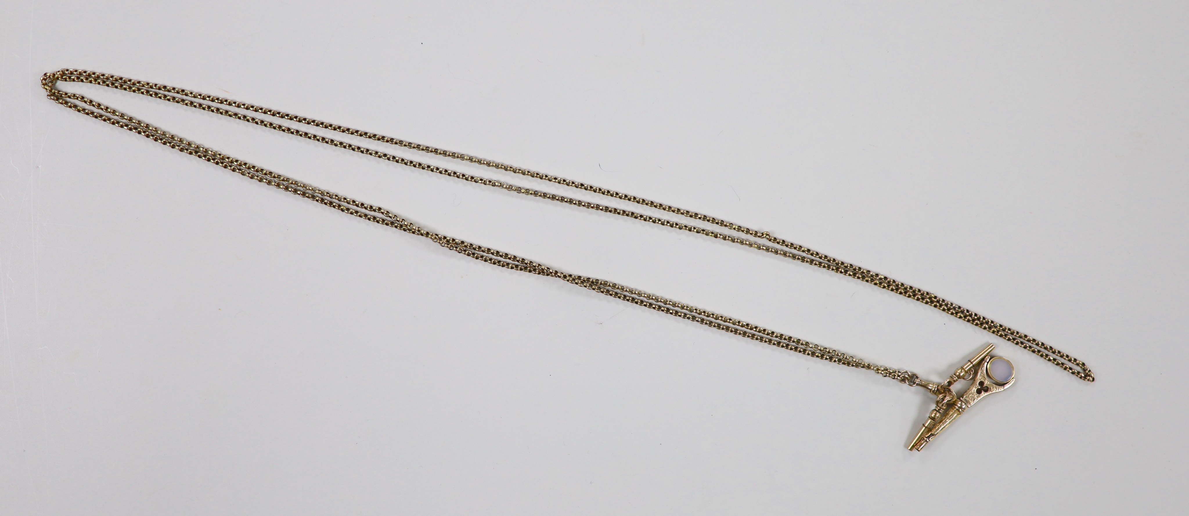 An Edwardian yellow metal guard chain, 170cm, 21.6 grams, hung with three yellow metal overlaid watch key fobs, one with set with bloodstone and carnelian stones